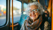 Portrait of a happy senior woman traveling by bus taking public transportation to reduce air pollution