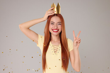 Poster - Beautiful young woman with princess crown under falling confetti on light grey background