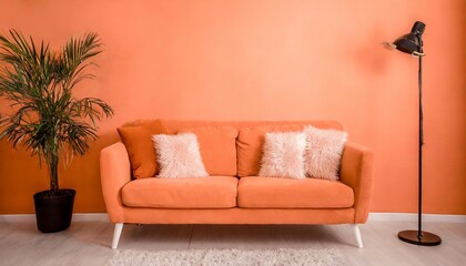 Wall Mural - an orange couch with four pillows on top of it peach fuzz trendy color of the year 2024