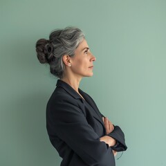 mature business woman standing on a pale green background whit crossed hands on the chest