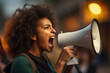 Closeup portrait of young African American woman shouting through megaphone while being on anti-racism protest.