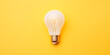 © Татьяна Гончарук - Photorealistic image of a white incandescent light bulb on a yellow background