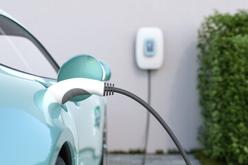 Charging an electric vehicle at home with a home charging station (wallbox). Focus on the plug in the car. Selective focus.