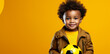 Little champion. Adorable african american baby boy with soccer ball over yellow background in studio, copy space