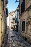 Fototapeta Uliczki - Morning walk along winding narrow streets with ancient stone buildings in the old town of Kotor, Montenegro
