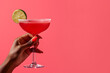 Summer concept - hand holding daiquiri cocktail, solid color background