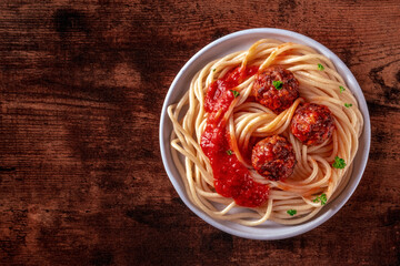 Wall Mural - Meatballs. Beef meat balls, overhead flat lay shot with spaghetti pasta, parsley, and tomato sauce, on a wooden background, with a place for text