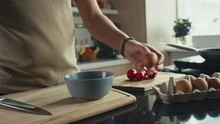 Close Up Shot Of Unrecognizable Man Cracking Two Eggs Into Bowl On Kitchen Table While Cooking Breakfast At Home