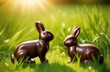 Two chocolate rabbits stand opposite each other in the grass. Sweets concept, Easter holidays, games for children, fun