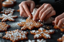 Aking, Cooking, Christmas, And Food Concept - Close Up Of Hands With Pastry Bag Decorating Gingerbread Cookies With White Icing On Black Table Top.