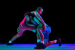 Two young, skilled and professional freestyle wrestlers in red and blue fighting uniform against black background in mixed neon lights. Concept of fair wrestling, championship, win competition.