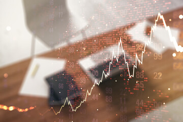 Double exposure of abstract creative financial diagram with world map and modern desk with computer on background, banking and accounting concept