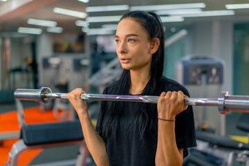 Wall Mural - young girl in sportswear in the gym doing barbell exercises fitness training healthy beautiful body