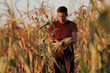 © Parilov - Portrait young man farmer in cornfield checks quality freshly harvested corn for making silo. Concept Farm silage production for food of cow