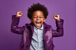 African American boy dressed stylish clothes celebrate success raise hands fists isolated on purple color background