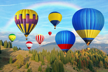 Wall Mural - Bright hot air balloons flying in sky with rainbow over mountain