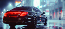 Luxury Black Car On A Wet City Street At Night With Bright City Lights And Reflections.