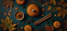  A Table Topped With Orange Pumpkins, Cinnamon Sticks, And A Cup Of Cinnamon On Top Of A Blue Surface Surrounded By Autumn Leaves And Pine Cones And Cones.