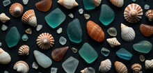  A Collection Of Sea Glass And Seashells On A Black Background, Top View, With A Shallow Focus On One Of The Shells And One Of The Seashells.