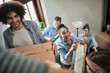 © Marko Geber - Group of friends moving into their new shared apartment