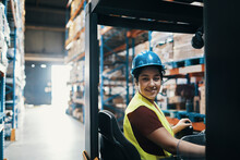 Young Female Warehouse Worker Operating Forklift
