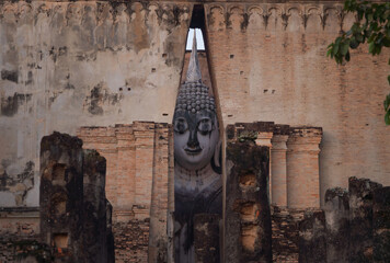 Wall Mural - The buddha in Wat Si Chum in Sukhothai Historical Park, pagoda stupa, Sukhothai, Thailand. Thai buddhist temple architecture. Tourist attraction.