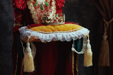 Wall Mural - Closeup on medieval queen in red dress with crown on pillow