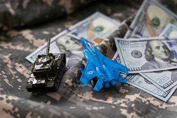 Toy tank on US hundred dollar bills banknotes close up. The concept of war costs, military spending and economic crisis