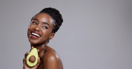 Poster - Beauty, avocado and woman laugh in studio for healthy cosmetics, nutrition or detox on grey background. Happy african model thinking of fruits for sustainable benefits, eco skincare or diet at mockup