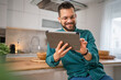 © Miljan Živković - One young adult caucasian man work use digital tablet online at home
