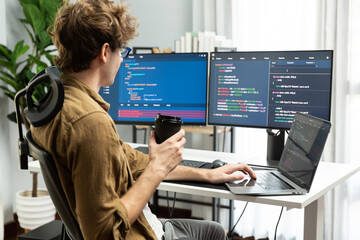 working it developer holding coffee cup with looking online software on pc at modern office on codin
