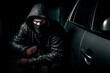 Anonymous thief with dark clothing stealing a car