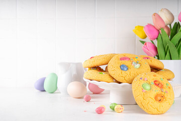 Wall Mural - Colorful Funfetti chocolate chips mix Cookies. Homemade sweet Easter vanilla biscuits with sugar sprinkles and chocolate Easter eggs, on white kitchen table background, with holiday decor