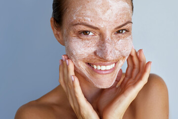 morning skin care routine. facial scrub, beauty portrait young happy woman with a freckles is applyi
