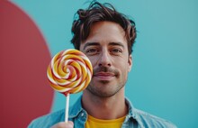 A Man Is Holding Up A Lollipop In Front Of A Blue Background