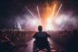 Silhouette of a person in a wheelchair enjoying a live music concert, highlighting accessibility in entertainment venues.