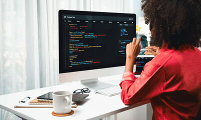 African American woman's programing developer. Coding Software project on computer screen server at home office. Concept of website designer in coder network information at work space. Tastemaker.