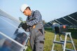 © Serhii - An Indian worker in uniform and with tools works on a solar panel farm