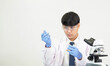 © Singh - Portrait asian man student scientist Wearing a doctor gown in the lab looking hand at chemist. caused by mixing reagents in scientific research laboratories with test tubes and microscope on the table