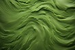  a close up of a green cake with swirly icing on it's edges and a black background.