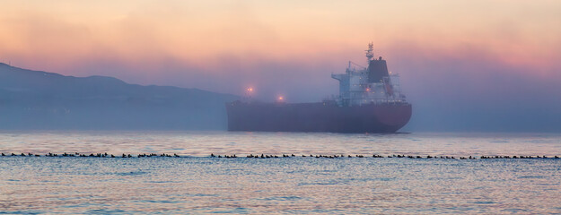 Wall Mural - Container Ship in Burrard Inlet during foggy sunset. Vancouver