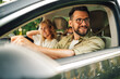 © Zamrznuti tonovi - Father driving a car and looking trough a window while traveling with his family