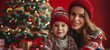 Close-up portrait of beautiful Caucasian mother and her little son in knitted sweaters and hats with gift boxes near the Christmas tree. Cheerful mom and cute child exchange gifts. Morning Christmas.