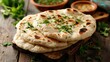 © buraratn - Indian naan bread on wooden table.