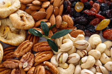 Wall Mural - Mixed nuts and dried fruits on a light concrete background. Symbols of Tu Bishva