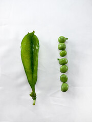 Fresh green empty peas and vegetable beans isolated on white cotton cloth background.