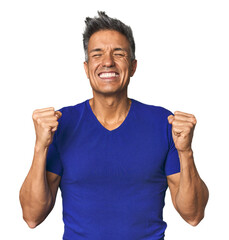 Middle-aged Latino man cheering carefree and excited. Victory concept.