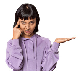 Poster - Young Hispanic woman with short black hair in studio holding and showing a product on hand.