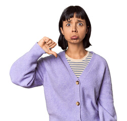 Wall Mural - Young Hispanic woman with short black hair in studio showing a dislike gesture, thumbs down. Disagreement concept.