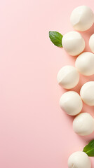 Mozzarella cheese balls on light pink background, top view, copy space	